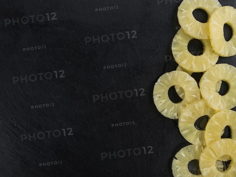 Some fresh Preserved Pineapple Rings on a vintage slate slab, selective focus, close-up shot