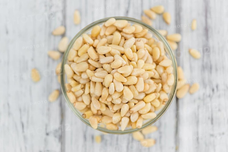 Portion of fresh Pine Nuts (close-up shot, selective focus)