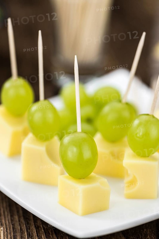 Cheese blocks with grapes as close-up shot (selective focus, partyfood)