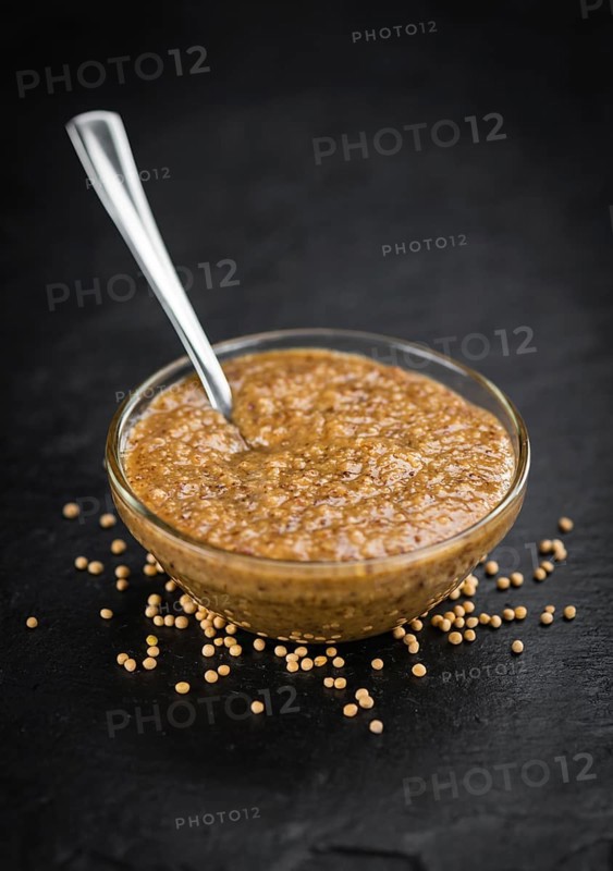 Some German Cuisine (sweet Mustard) on a slate slab (close-up shot, selective focus)