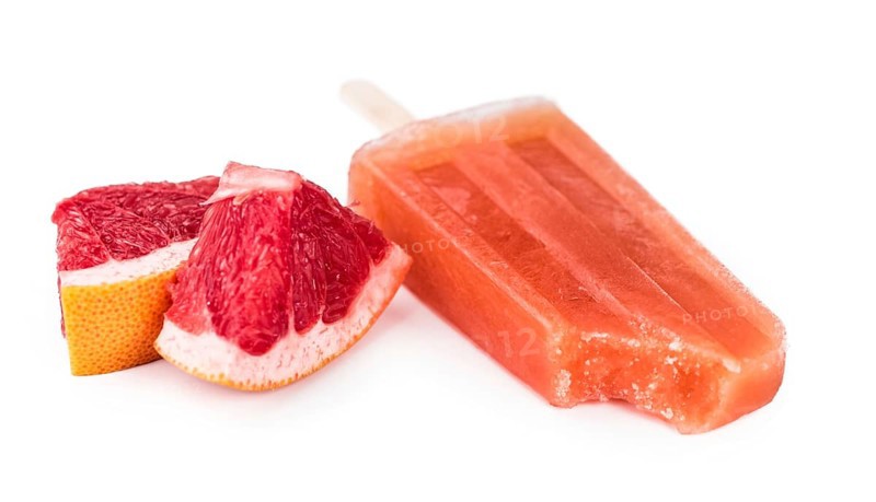 Portion of homemade Grapefruit Popsicles isolated on white background (selective focus)