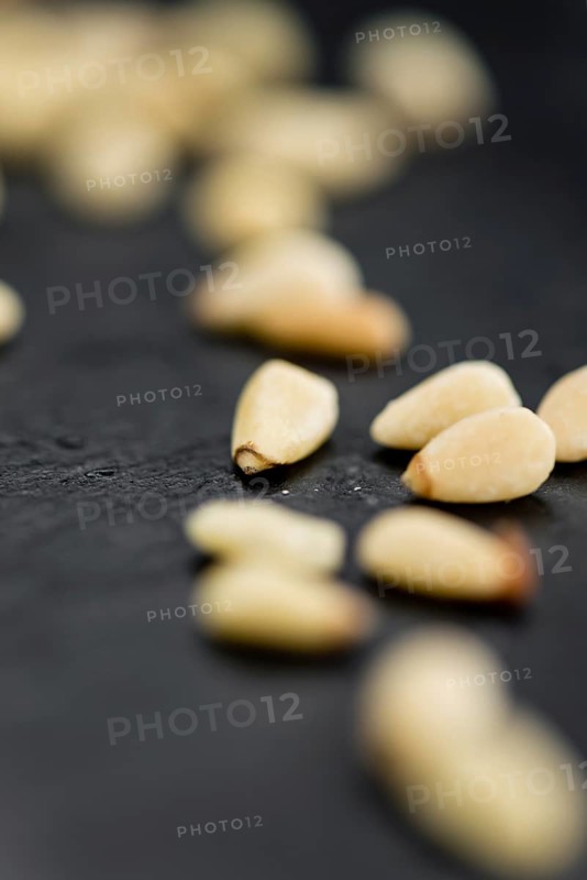 Portion of Pine Nuts as detailed close up shot on a slate slab (selective focus)