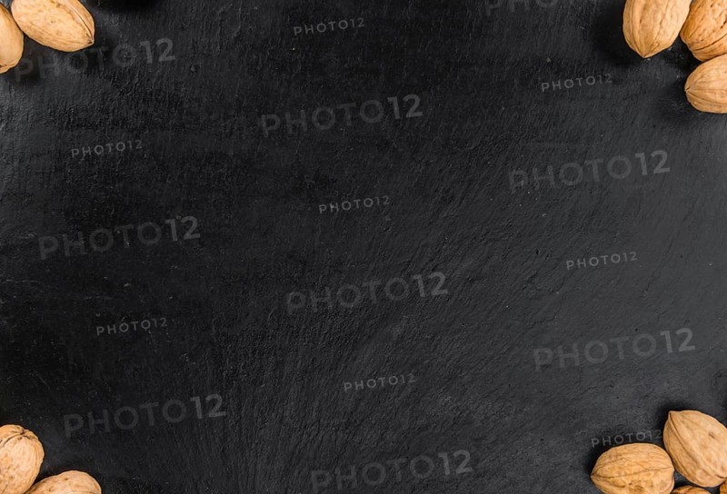 Portion of Whole Walnuts on a rustic slate slab (selective focus, close-up shot)