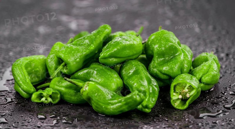 Portion of Raw Pimientos on a rustic slate slab, selective focus, close-up shot