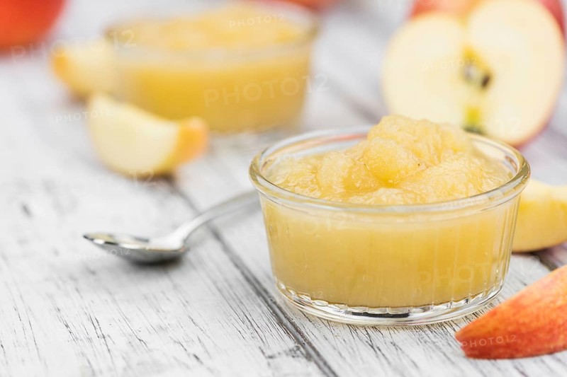 Portion of fresh made Applesauce (selective focus) on a wooden table