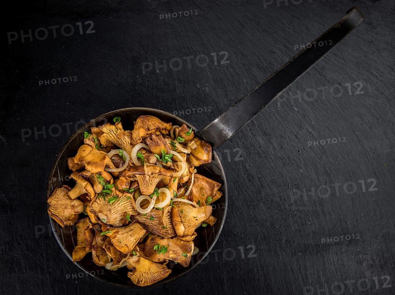 Portion of Fried Chanterelles on a rustic slate slab, selective focus, close-up shot
