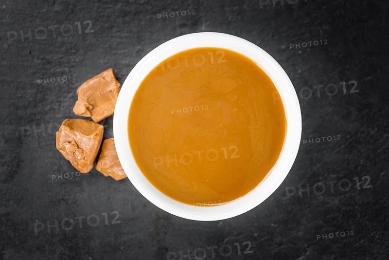 Portion of fresh Caramel Sauce (close-up shot, selective focus)