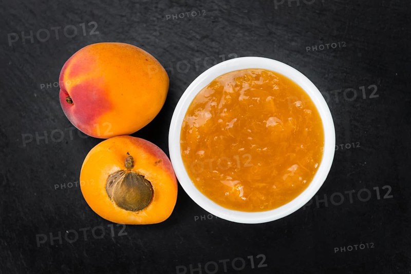 Portion of Apricot Jam as detailed close up shot on a slate slab (selective focus)