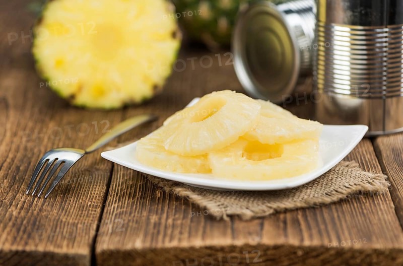 Fresh made Preserved Pineapple Rings on a vintage background as detailed close-up shot