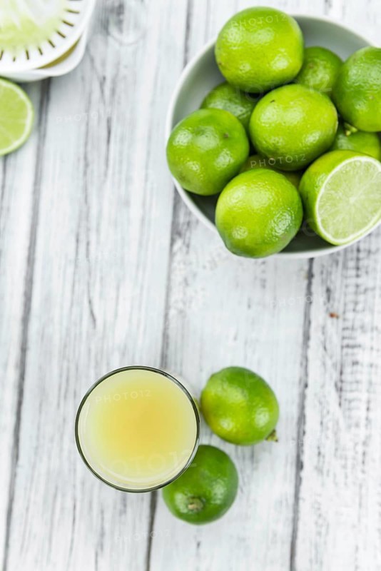 Fresh made Fresh Lime Juice on an old and rustic wooden table (selective focus, close-up shot)