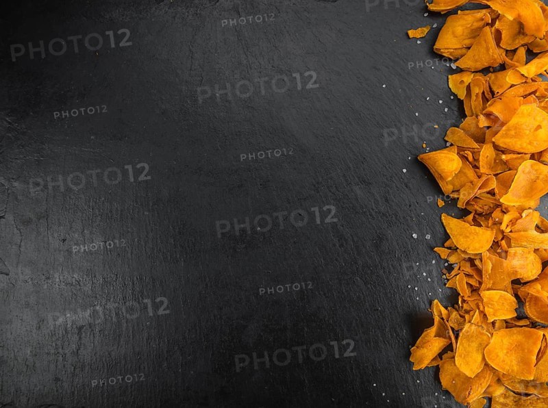 Some fresh Sweet Potato Chips on a vintage slate slab, selective focus, close-up shot
