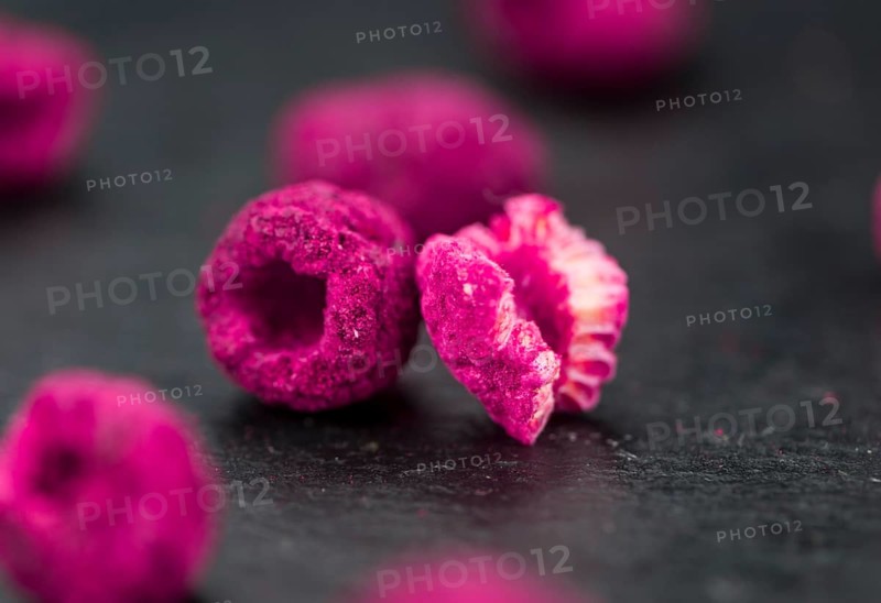 Dried Raspberries on a vintage slate slab as detailed close-up shot, selective focus