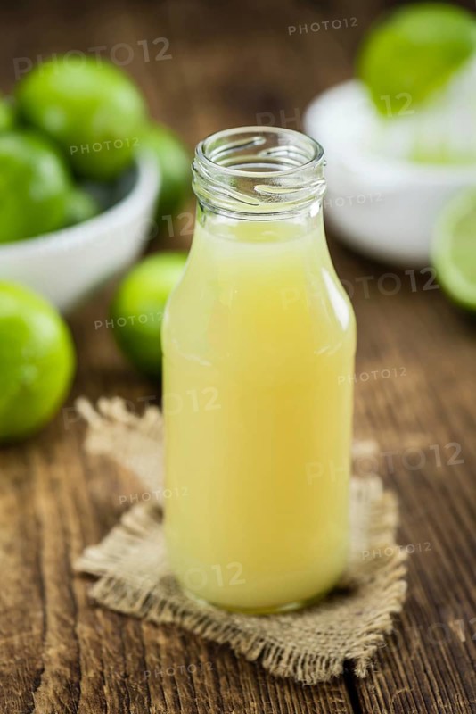 Lime Juice on a vintage background as detailed close-up shot (selective focus)