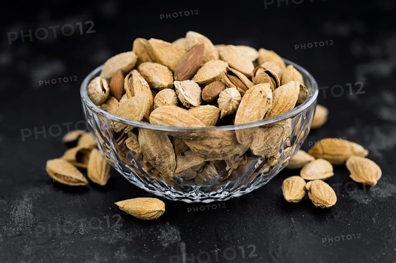 Dark slate slab with roasted and salted Almonds (in the shell)