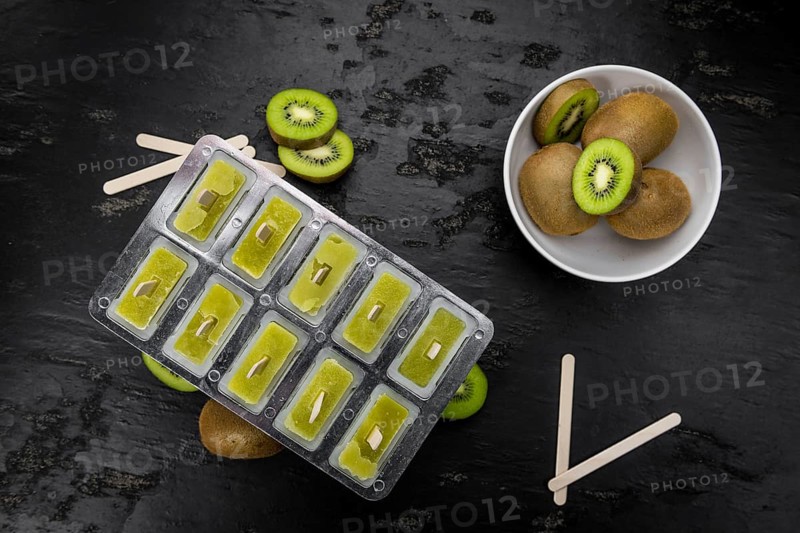 Portion of fresh made Kiwi Popsicles on a slate slab (selective focus)