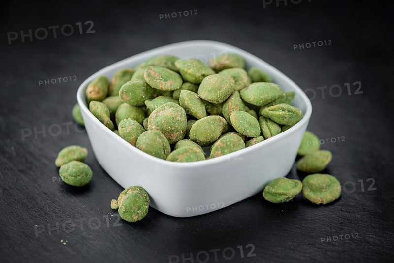 Some fresh Wasabi Peanuts on a vintage slate slab (selective focus, close-up shot)