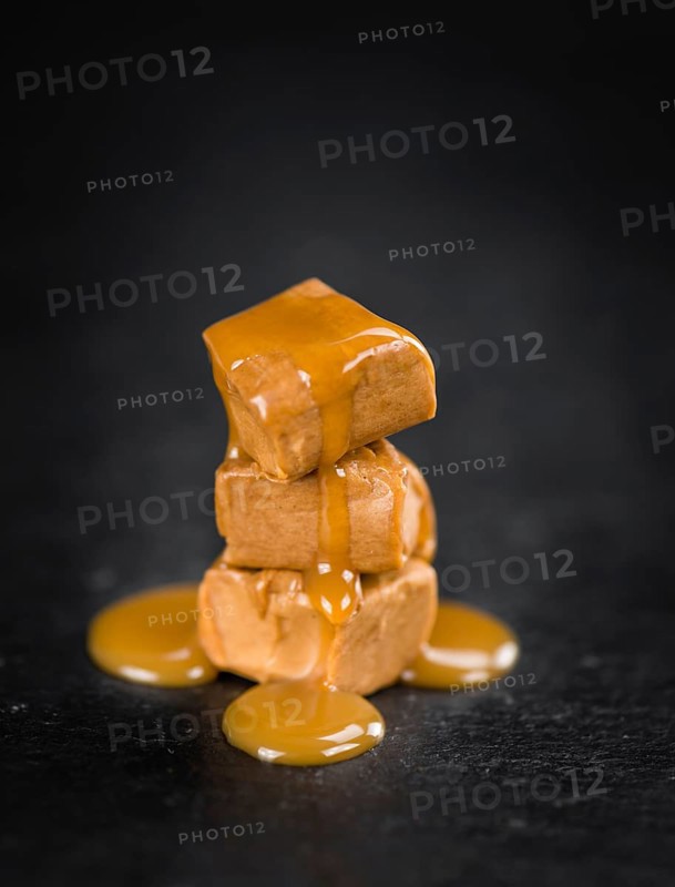 Caramel Sauce on a vintage background as detailed close-up shot (selective focus)