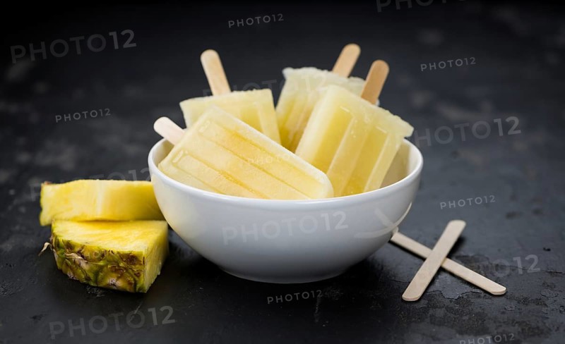 Homemade Pineapple Popsicles on a slate slab (selective focus, close-up shot)