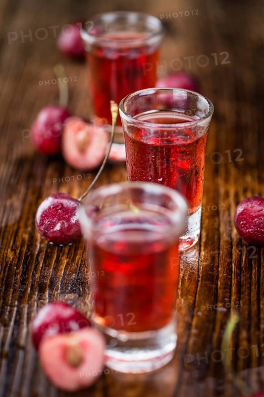 Homemade Cherry Liqueur on vintage background selective focus, close-up shot