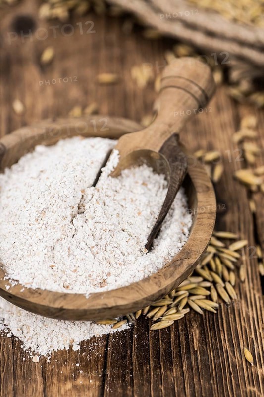 Vintage wooden table with Oat Flour (selective focus, close-up shot)