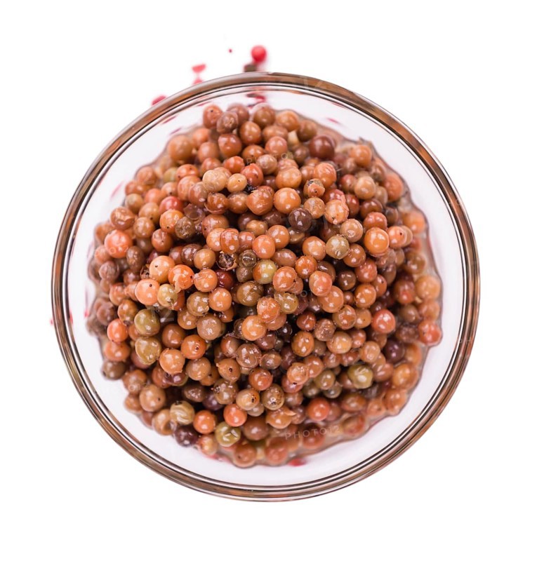 Preserved Pink Peppercorns isolated on white background, selective focus, close-up shot