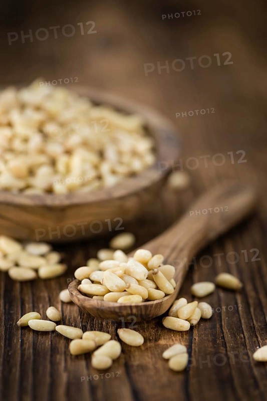 Pine Nuts on an old wooden table as detailed close-up shot (selective focus)