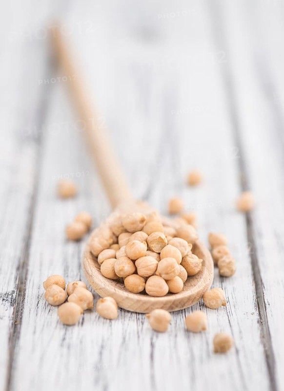 Dried Chickpeas as high detailed close-up shot on a vintage wooden table, selective focus