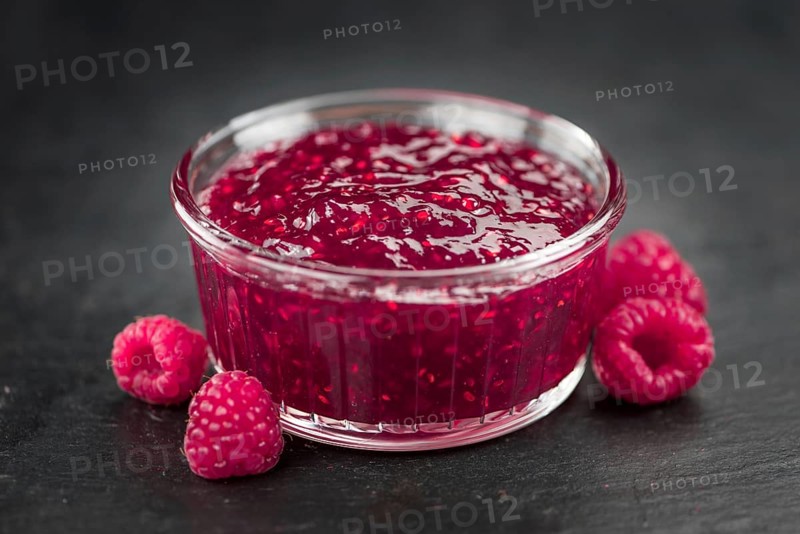 Some Raspberry Jam on a slate slab as detailed close-up shot, selective focus