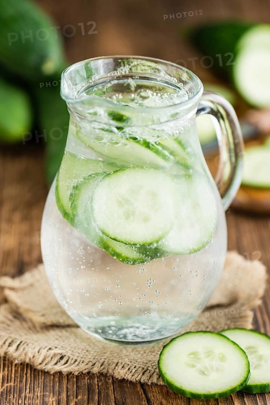 Cucumber Water on rustic wooden background as close-up shot