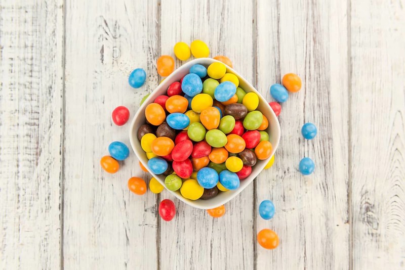Fresh made Cocolate coated Peanuts on a vintage background (close-up shot)