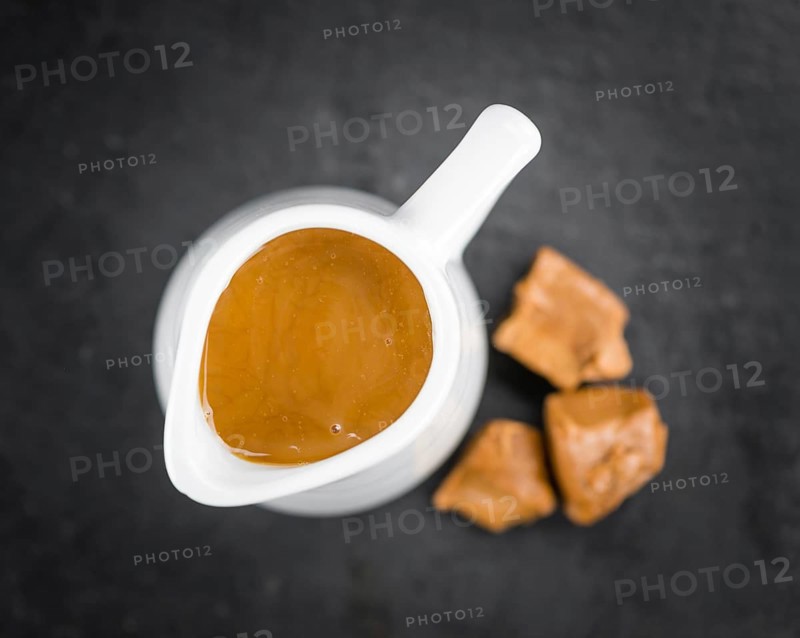 Caramel Sauce on a vintage slate slab (close-up shot, selective focus)