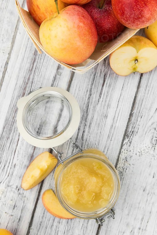 Portion of fresh made Applesauce (selective focus) on a wooden table