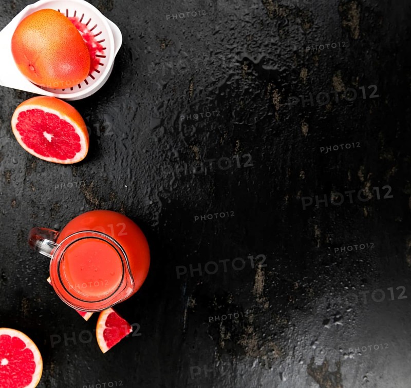 Slate slab with freshly squeezed Grapefruit Juice (selective focus, close-up shot)