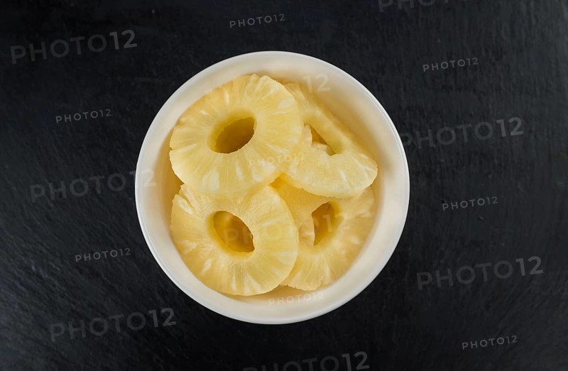Some fresh Preserved Pineapple Rings on a vintage slate slab, selective focus, close-up shot