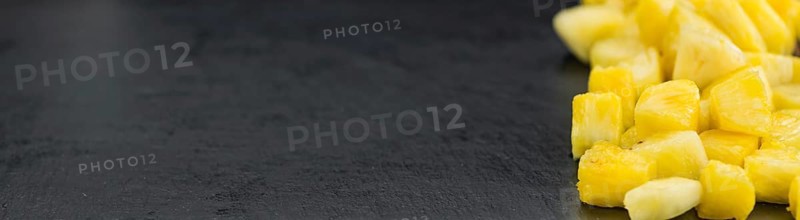 Portion of Pineapple (sliced) on a rustic slate slab, selective focus, close-up shot