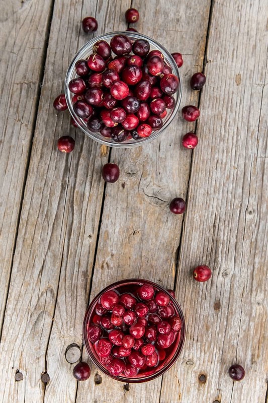 Vintage wooden table with Cranberries (preserved) (selective focus, close-up shot)