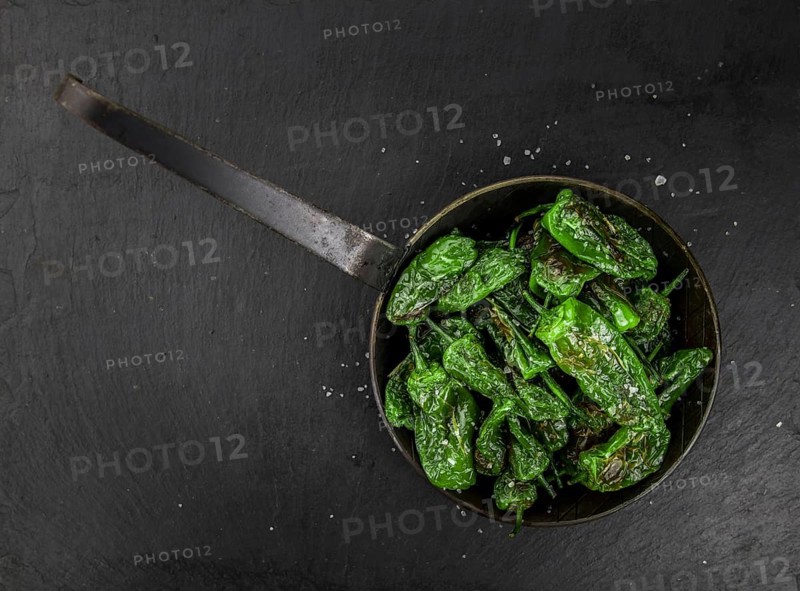 Portion of Pimientos de Padron on a rustic slate slab, selective focus, close-up shot