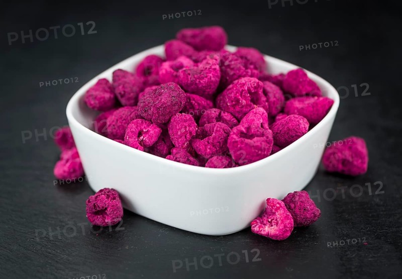 Portion of Dried Raspberries as detailed close up shot on a slate slab, selective focus