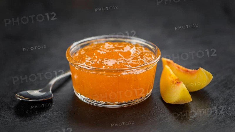 Portion of fresh Peach Jam close-up shot, selective focus