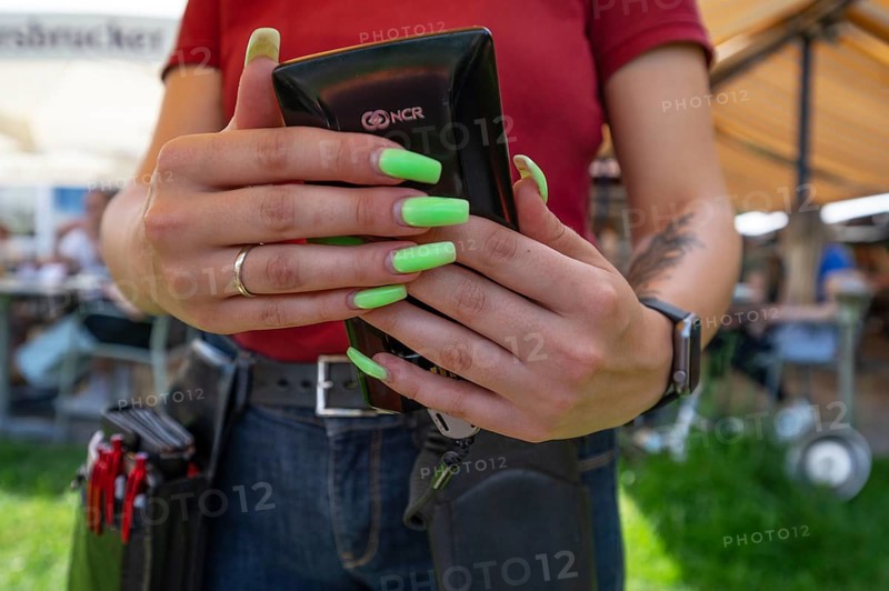 Waitress with long green painted fingernails, cashing up food and drinks in a garden restaurant, Basyern, Germany, Europe