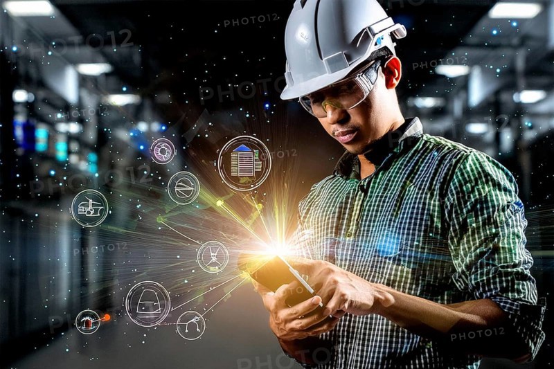 Worker with hard hat and tablet, surrounded by holographic symbols, standing in an industrial environment, AI and illustration technology, AI generated