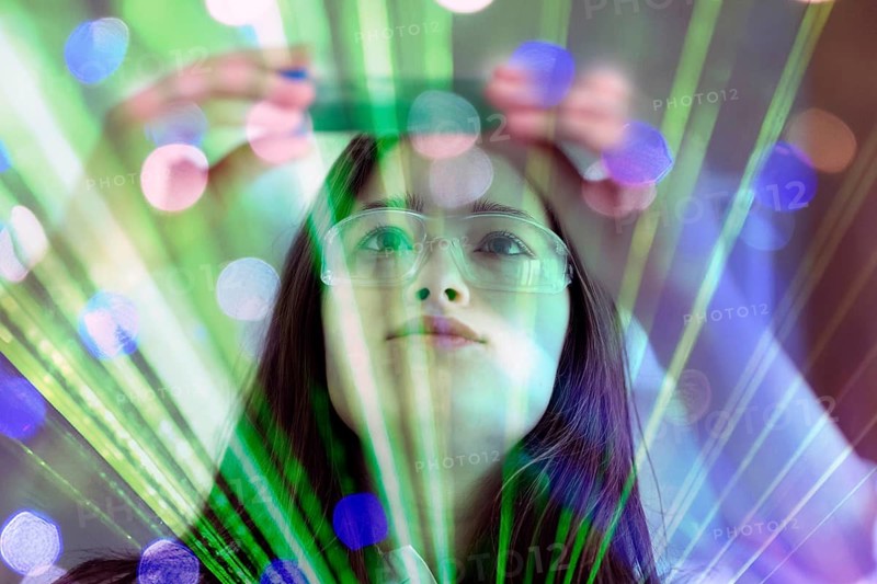 A woman in safety goggles works intently with green light and laser effects, AI and illustration technology, AI generated