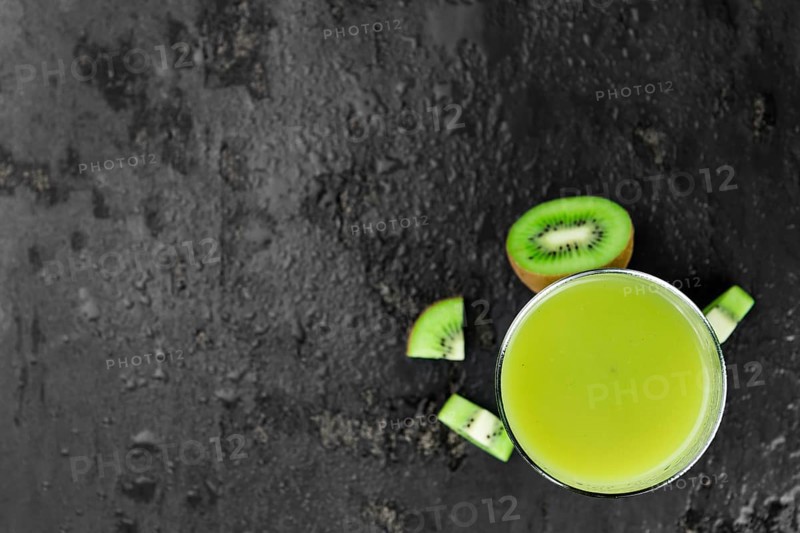 Some fresh homemade Kiwi Smoothies on a slate slab (close-up shot, selective focus)