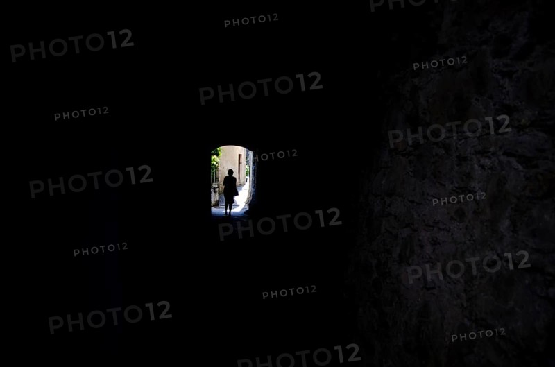 Woman Walking in a Dark Tunnel with Sunlight in Gandria, Ticino, Switzerland, Europe