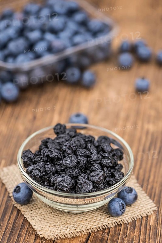Dried Blueberries as high detailed close-up shot on a vintage wooden table, selective focus