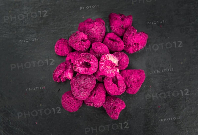 Dried Raspberries on a vintage slate slab as detailed close-up shot, selective focus