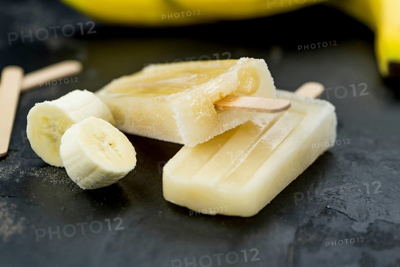 Homemade Banana Popsicles on a vintage background (close-up shot, selective focus)