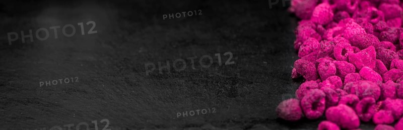 Portion of Dried Raspberries as detailed close up shot on a slate slab, selective focus