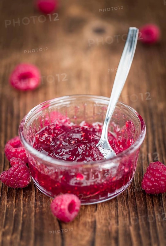 Fresh made Raspberry Jam on an old and rustic wooden table, selective focus, close-up shot