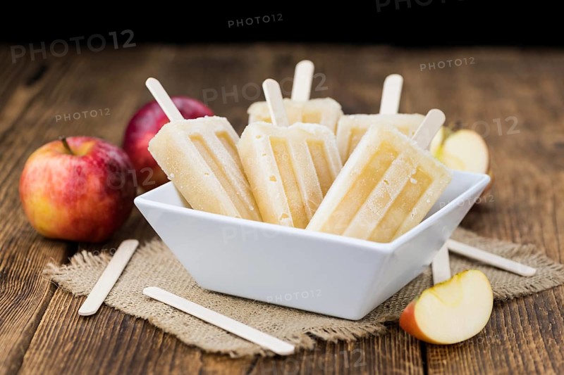 Apple Popsicles on an old wooden table (close-up shot, selective focus)